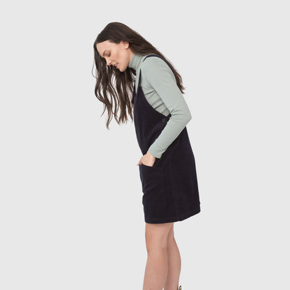 Night Sky Corduroy Overall Dress (Side): Dark navy corduroy pinafore dress with pockets, worn over mint turtleneck