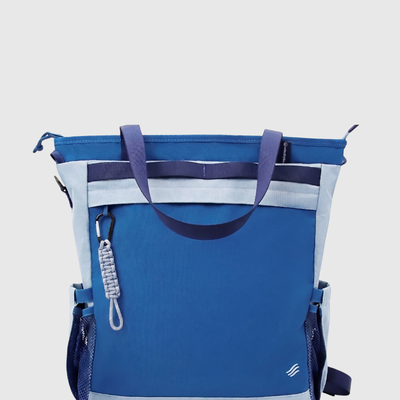 Navy (R)evolution™ 25L Convertible Carryall (Back): Blue tote bag with light blue panels, carabiner zipper pull, mesh side pockets