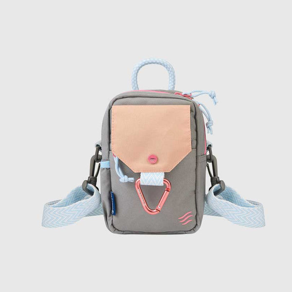 Lt Grey (R)evolution™ Daily Cross Body (Front): Grey crossbody bag with peach pocket flap, pink carabiner, and light blue strap