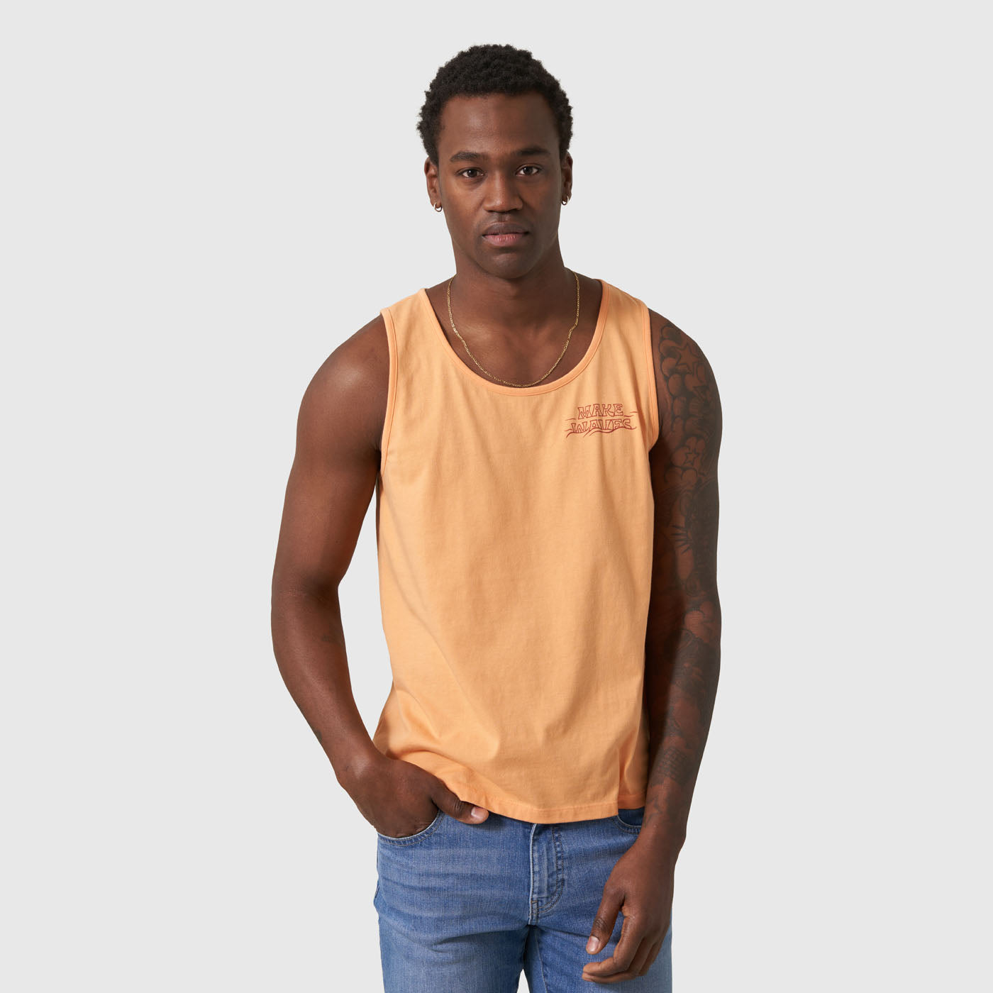 Make Waves Papaya Graphic Tank (In-use): Peach sleeveless tank with small red chest logo, worn with blue jeans