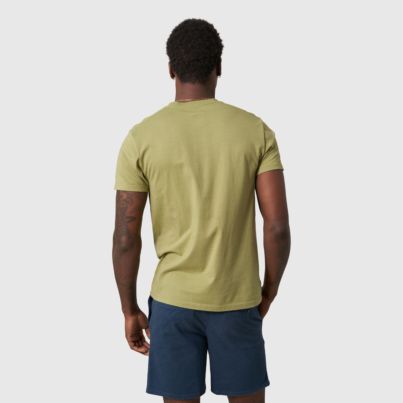 Sage Outdoors For All Graphic Tee (Back): Back view of olive green short-sleeve tee with navy shorts