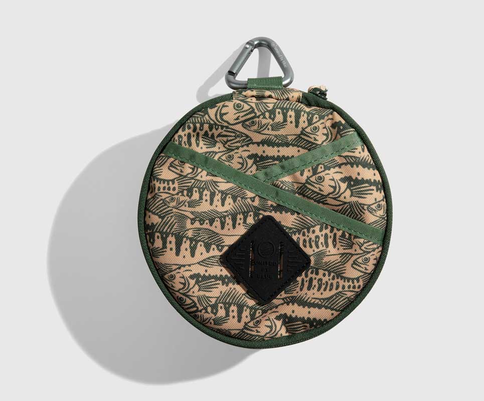 Cortado The Meal Kit (Single) (Front): Round tan pouch with fish print, green straps, carabiner clip, diamond logo patch