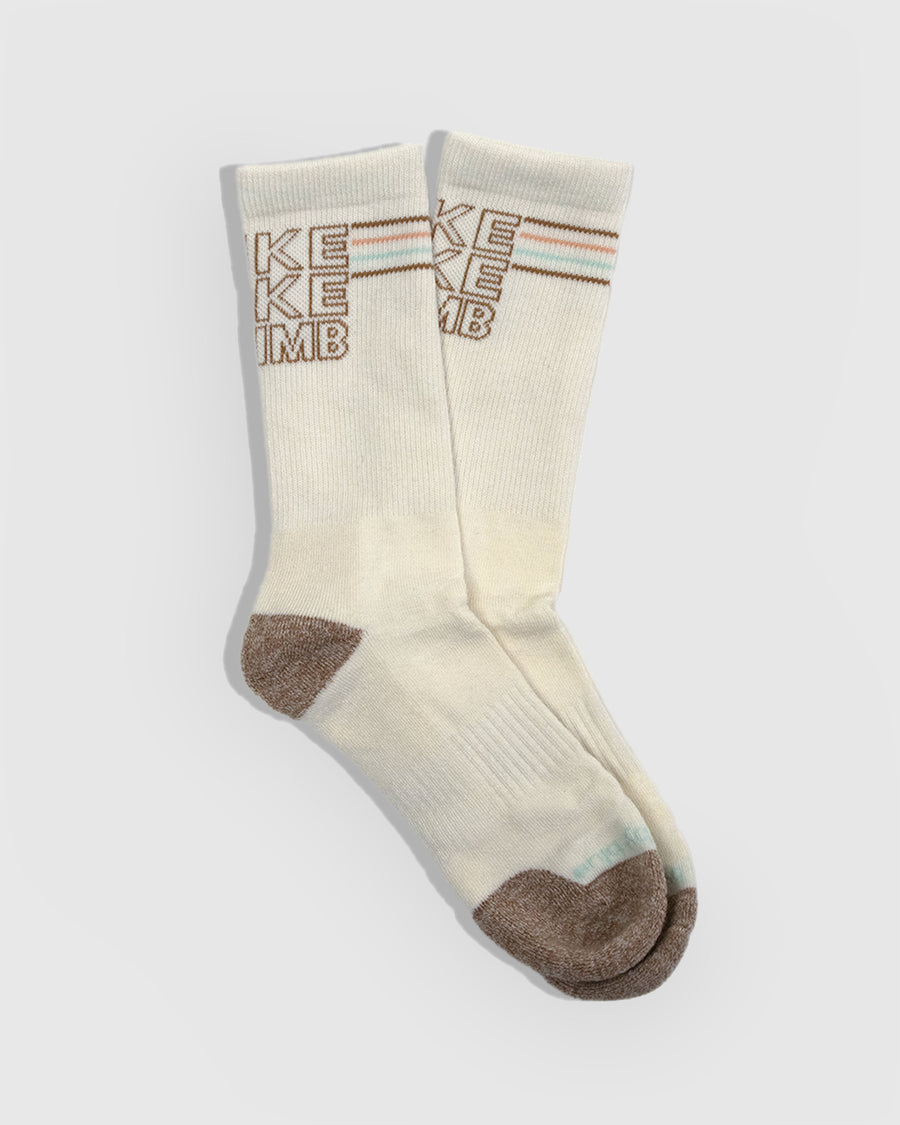 HikeBikeClimb - Natural Merino Wool - Graphic Crew Sock (Flat-lay): Cream crew socks with brown knit HIKE BIKE CLIMB text and toe