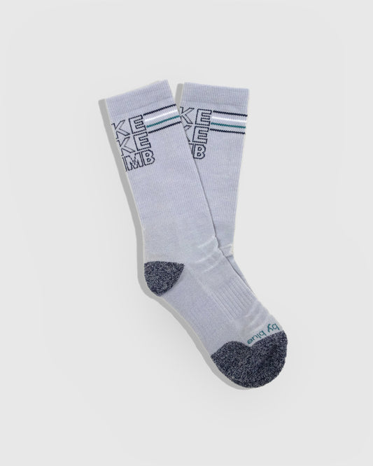 HikeBikeClimb - Periwinkle Merino Wool - Graphic Crew Sock (Flat-lay): Periwinkle crew socks with navy knit HIKE BIKE CLIMB text, marled toe