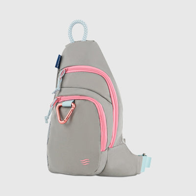 Lt Gray (R)evolution Sling Pack (Angle): Gray sling pack with pink zippers, carabiner clip, and light blue accents