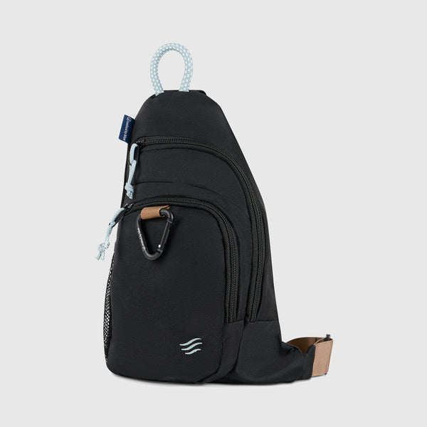 Black (R)evolution Sling Pack (Angle): Black sling pack with multiple zippered pockets, carabiner, and rope loop handle