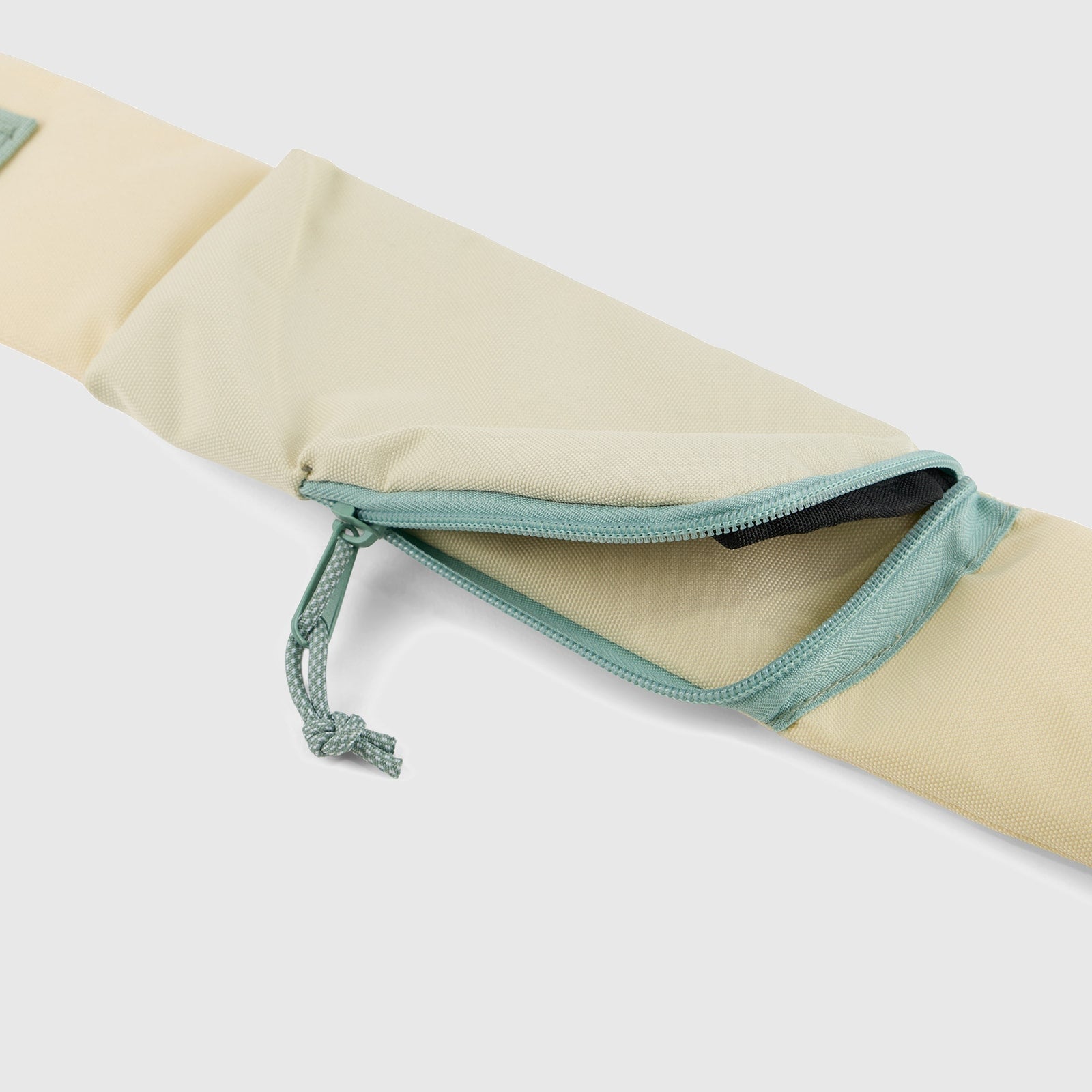 Pink Multi (R)evolution Sling Pack (Detail): Close-up of cream strap pocket with mint zipper and hidden zip stash compartment