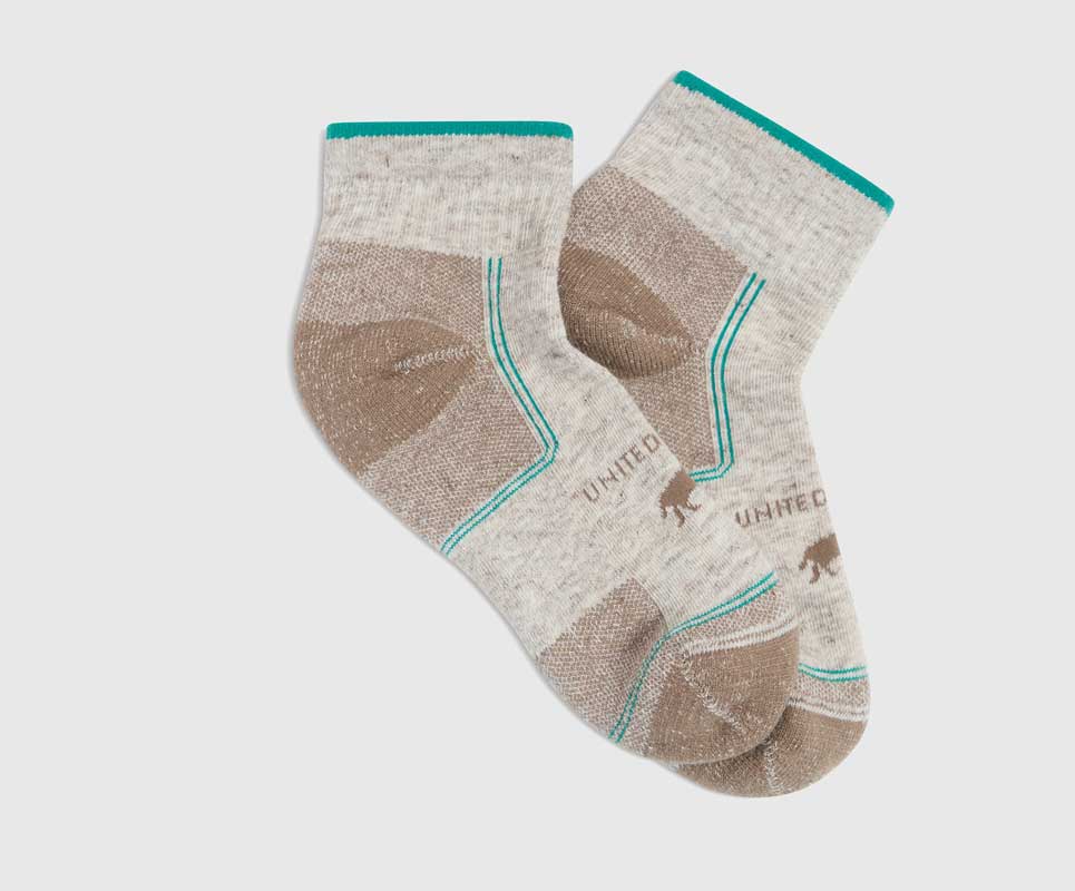 Taupe Bison Trail Quarter Sock (Flat-lay): Pair of quarter-cut socks, oatmeal with tan heel and toe accents, teal trim