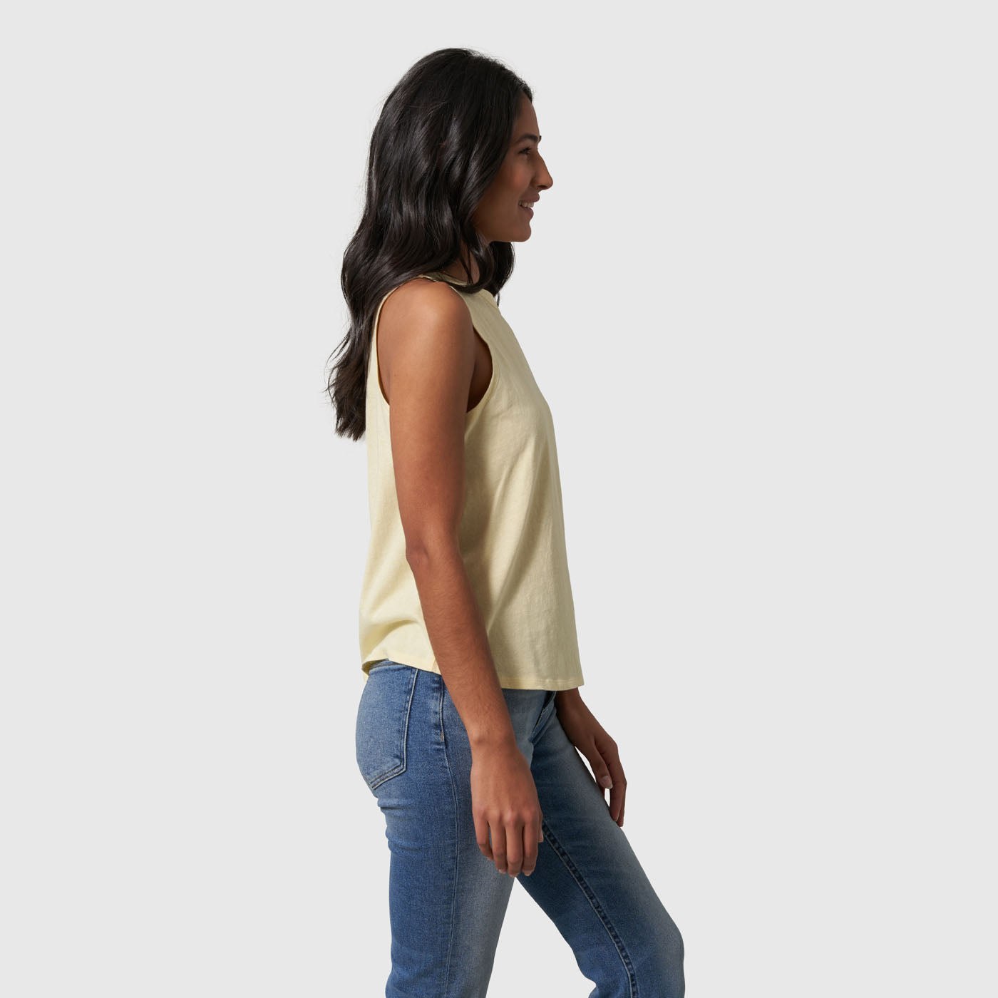 Yellow Women's SoftHemp™ High Neck Tank (Side): Side view of pale yellow sleeveless high neck tank tucked into blue jeans
