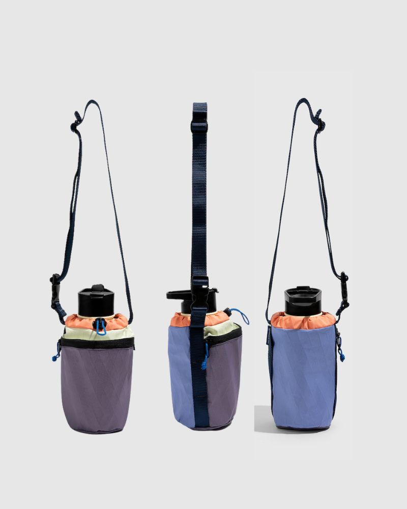 Plum Blue Water Bottle Sling - Westward (Pre-Release) (Angle): Three views of purple-blue bottle carrier with orange drawstring top and crossbody strap