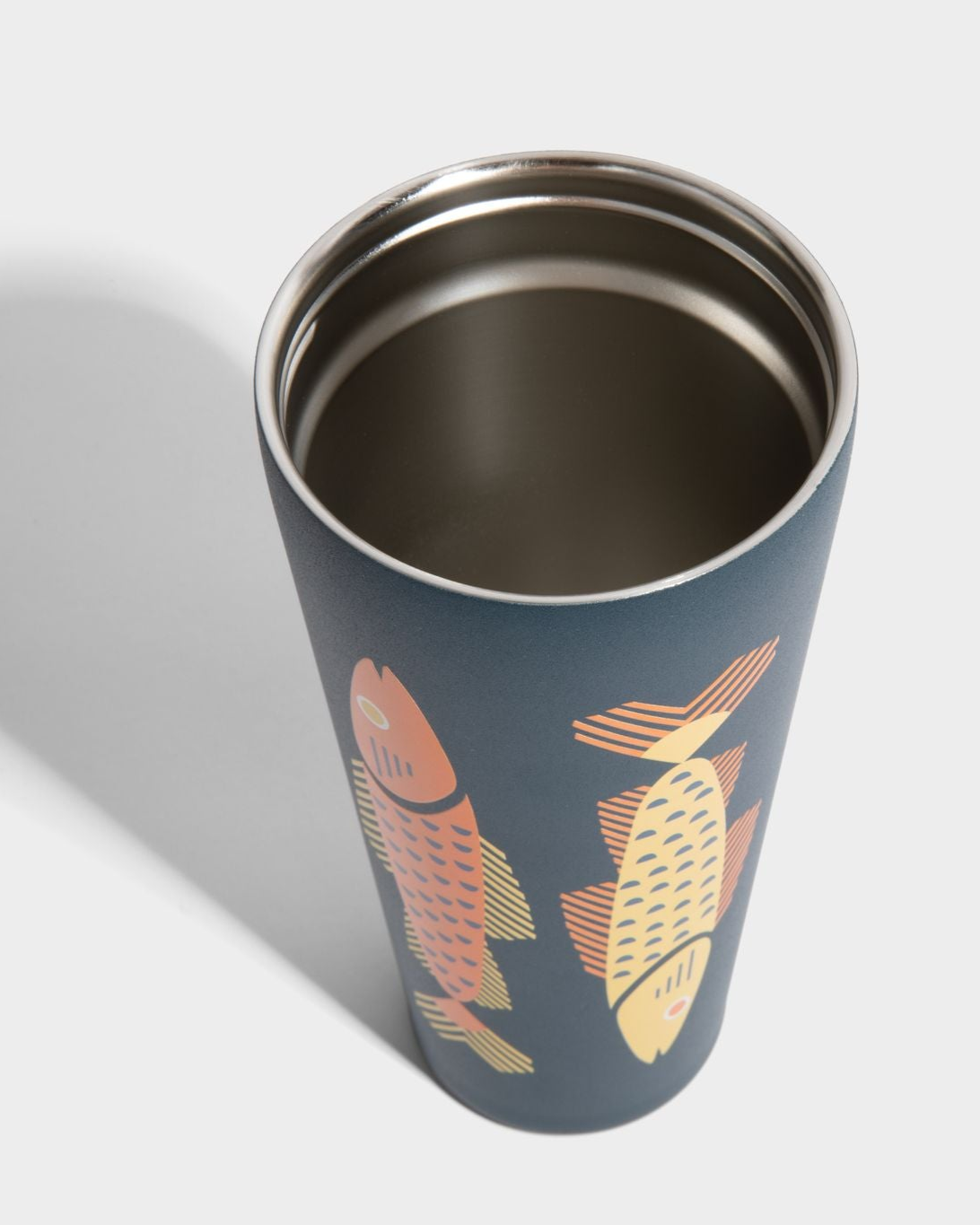 Rainstorm - Fish 24 oz Insulated Steel Straw Tumbler (Detail): Dark navy tumbler with orange and yellow geometric fish illustrations, stainless interior visible