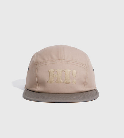 Tan Hi Organic 5-Panel Hat (Angle): Tan five-panel cap with embroidered HI! text and darker gray brim