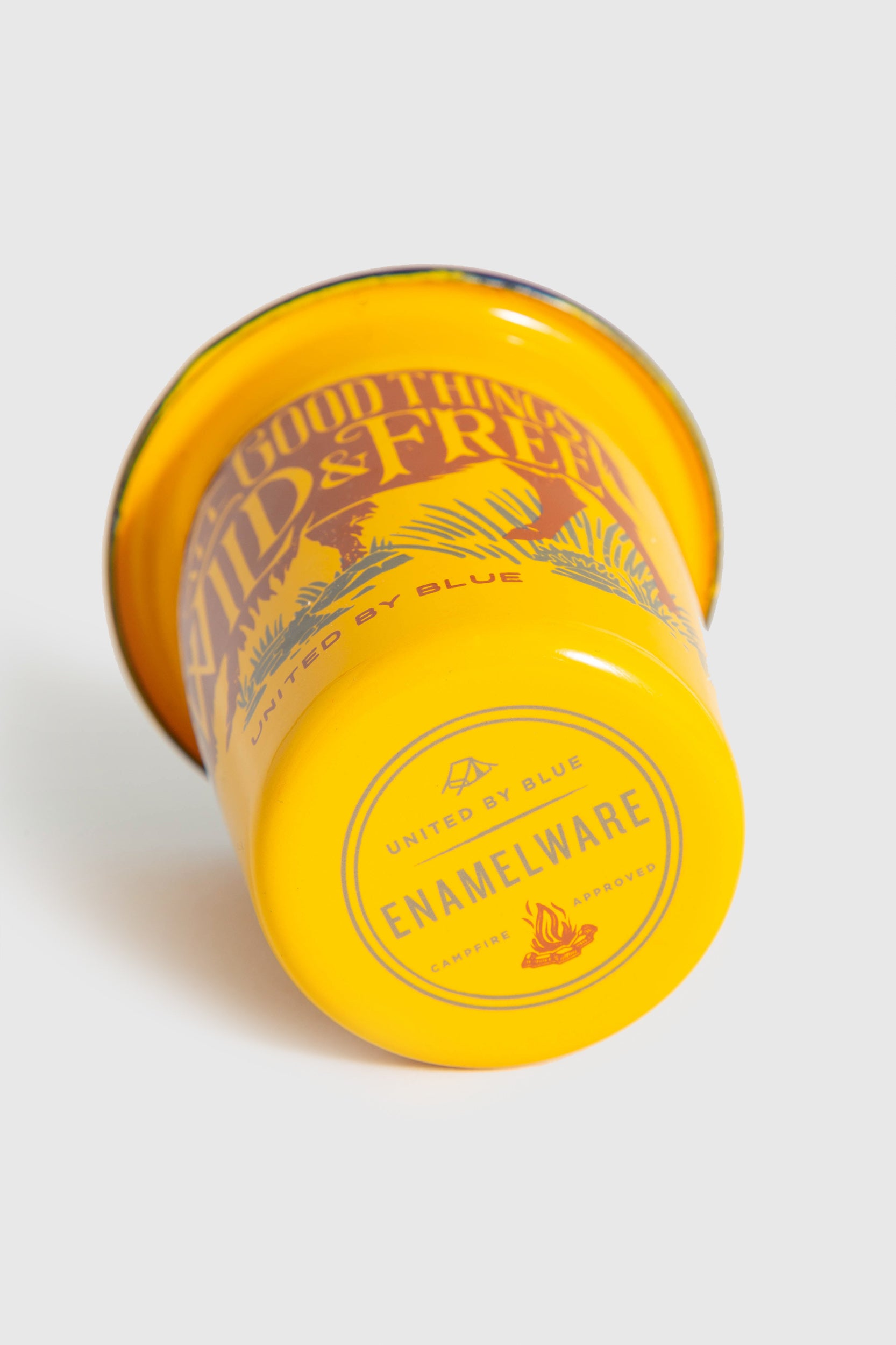 WILD AND FREE WILD AND FREE – 12OZ. ENAMEL TUMBLER (Detail): Yellow enamel tumbler bottom showing United By Blue campfire approved stamp