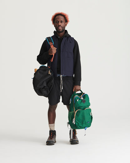 Black Recycled Sport Short (In-use): Man wearing black shorts with drawstring waist, holding multiple bags