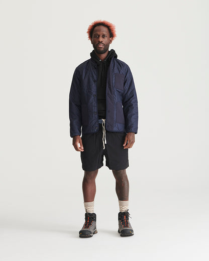 Night Sky Bison Ultralight Liner Jacket (In-use): Man wearing open navy quilted jacket over black hoodie and shorts