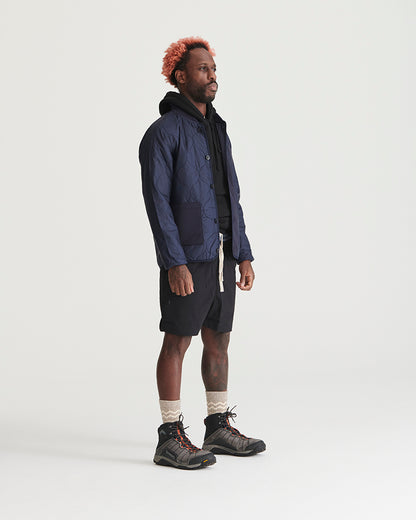 Night Sky Bison Ultralight Liner Jacket (Angle): Man wearing navy quilted button-front liner jacket with black shorts and hiking boots