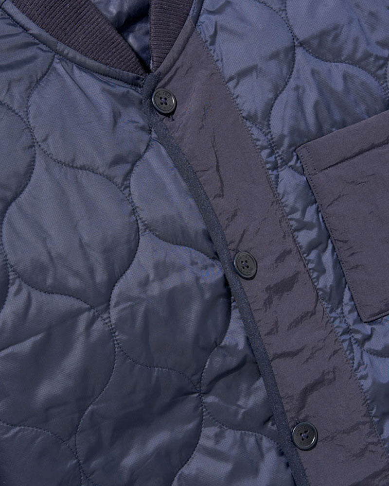 Night Sky Bison Ultralight Liner Jacket (Detail): Navy quilted fabric with curved stitching, button placket, and chest pocket