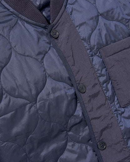 Night Sky Bison Ultralight Liner Jacket (Detail): Navy quilted fabric with curved stitching, button placket, and chest pocket