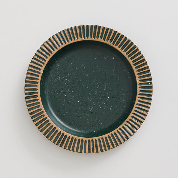 Pine Stoneware Stackable Plate (Flat-lay): Round dark green speckled plate with carved tan ribbed border design
