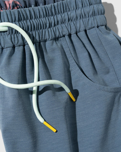 Stone Blue The Responsible Swim Short (Detail): Steel blue shorts with mint drawstring, yellow aglets, and side pocket