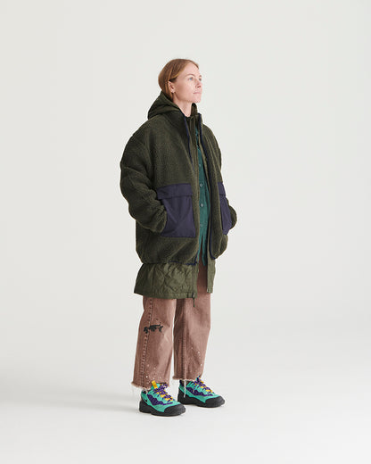 Forest Floor Bison Ultralight Long Liner Jacket (In-use): Woman wearing dark olive sherpa jacket with navy nylon pocket panels layered over hoodie