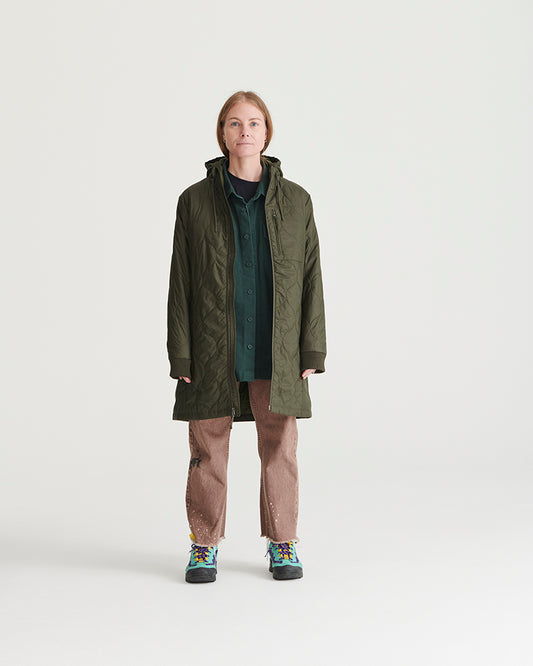 Forest Floor Bison Ultralight Long Liner Jacket (In-use): Woman wearing open olive quilted hooded long jacket over green shirt