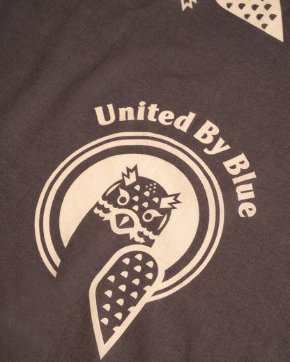 Dark Brown Organic Hoot Bandana (Detail): Dark brown bandana with cream owl logo and United By Blue text