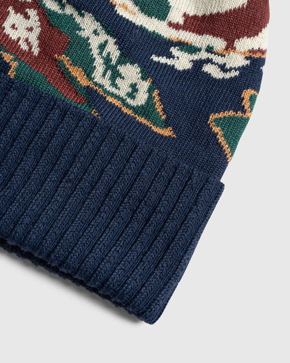 Lakeside Camo Recycled Novelty Pom Beanie (Detail): Close-up of navy ribbed cuff with multicolor intarsia knit pattern above