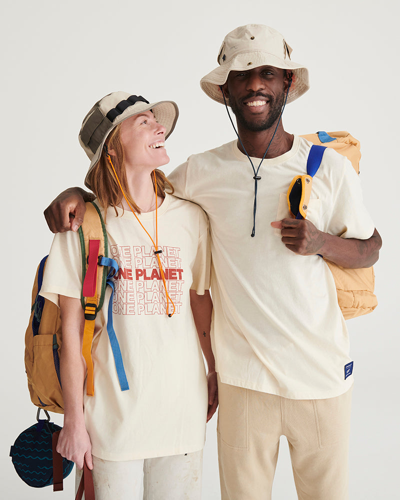 Bone Organic Bucket Stash Hat (In-use): Two smiling people wearing cream bucket hats with chin cords outdoors