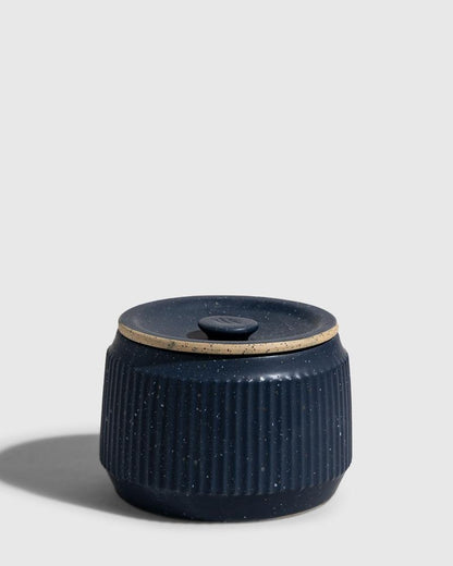 INDIGO 14 oz. Ceramic Keepsake Candle - Surf (Front): Dark navy speckled ceramic jar with ribbed sides and fitted lid