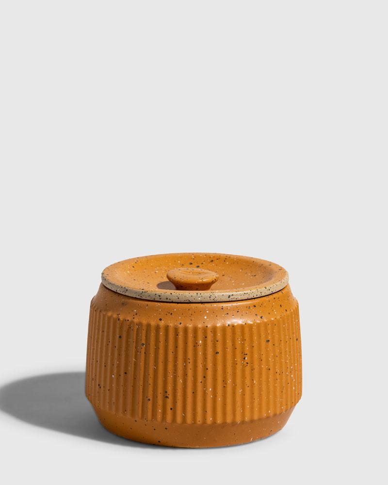CARAMEL 14 oz. Ceramic Keepsake Candle - Mountain Peak (Front): Round lidded ceramic jar with ribbed sides, small knob handle, speckled glaze
