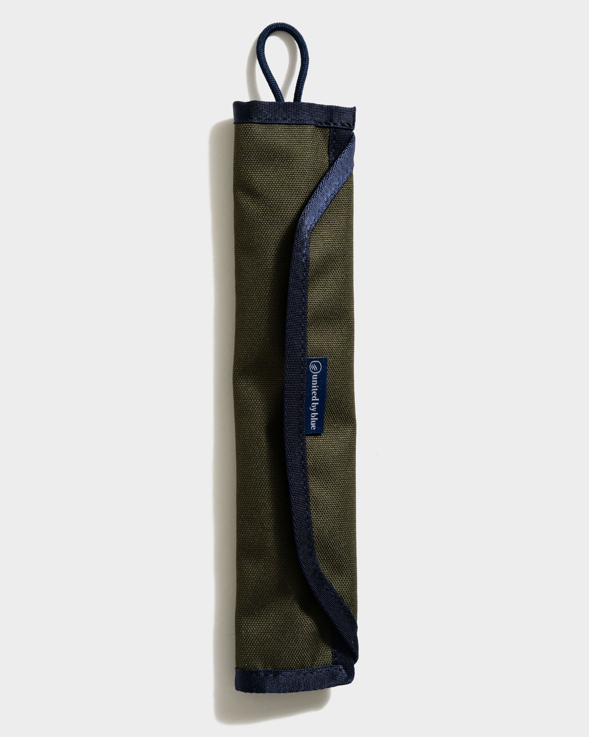 Olive The Straw Kit (Front): Rolled olive canvas case with navy trim, loop handle, and brand label