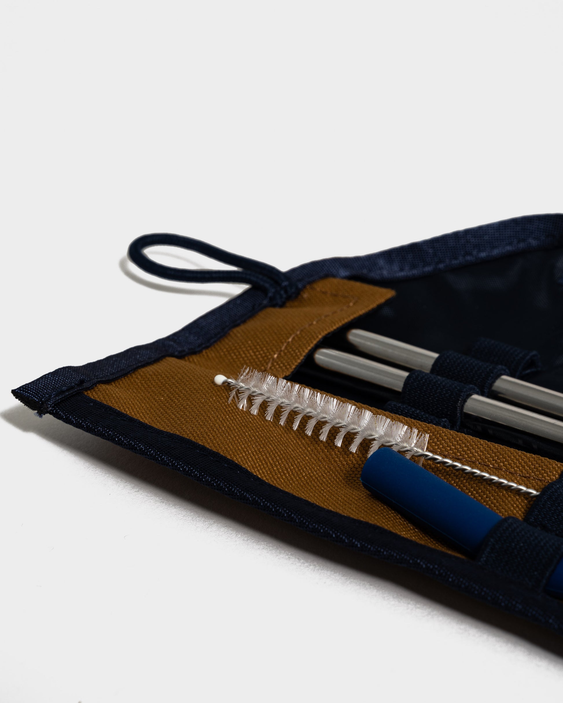 Camel The Straw Kit (Detail): Navy roll pouch open, showing steel straws, cleaning brush, and blue tip