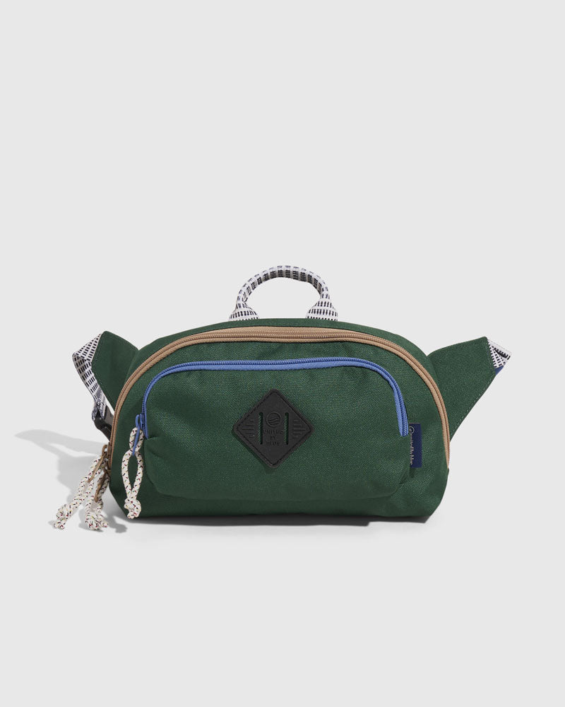 Pine (R)evolution™ 3L Utility Fanny Pack (Front): Dark green fanny pack with blue zipper, rope pull, and diamond logo patch