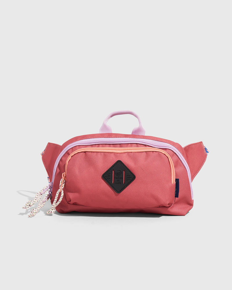 (R)evolution™ 3L Utility Fanny Pack (Front): Dusty rose fanny pack with lavender zipper trim, front pocket, and carry handle