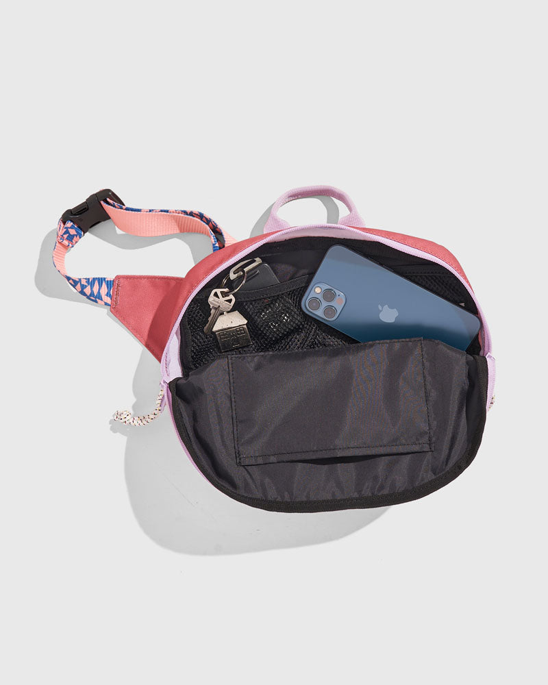 (R)evolution™ 3L Utility Fanny Pack (Detail): Open fanny pack interior showing mesh pocket, keys, and blue smartphone