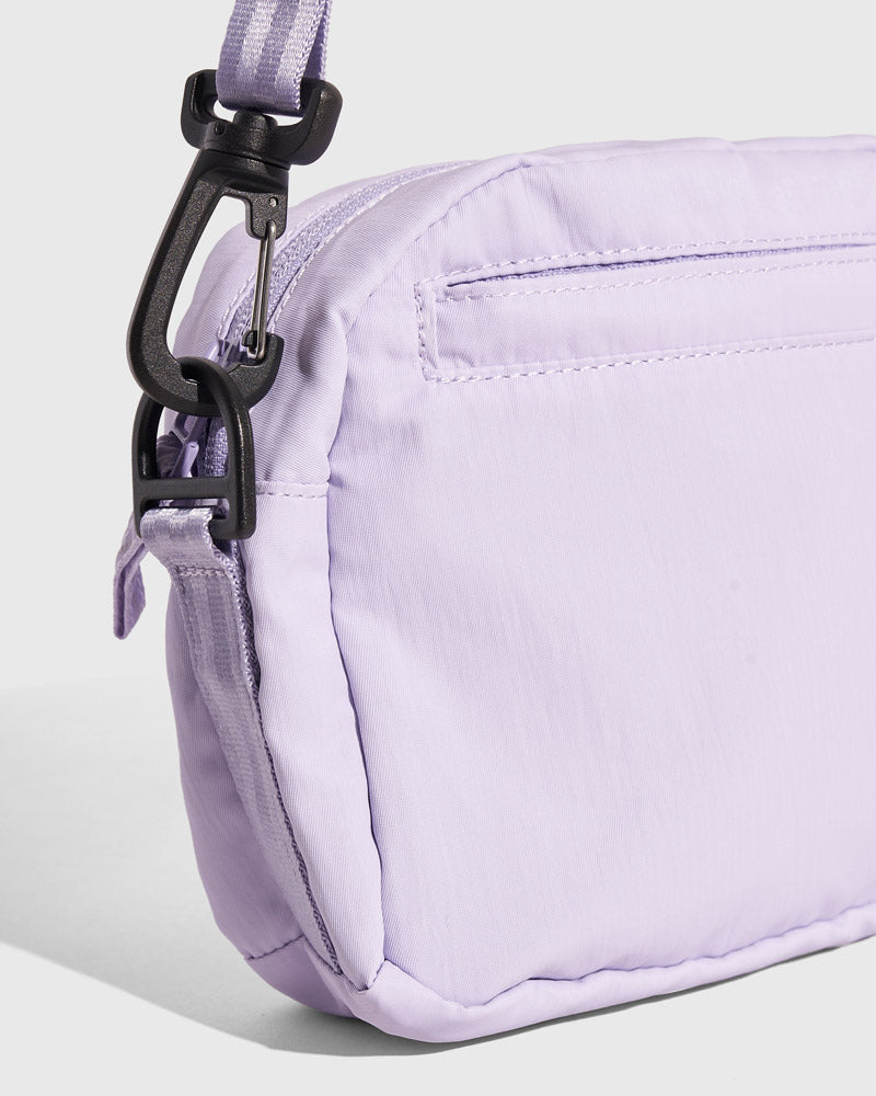 Lavender (Re)active™ 2L Convertible Crossbody (Detail): Light purple nylon bag side panel with black clip hardware attachment