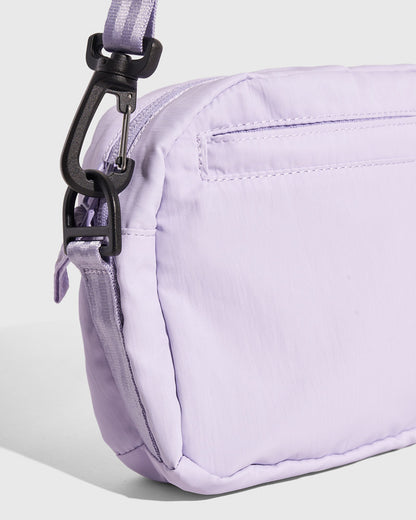 Lavender (Re)active™ 2L Convertible Crossbody (Detail): Light purple nylon bag side panel with black clip hardware attachment