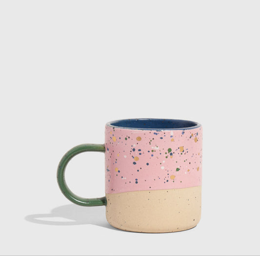 Lilac 8 oz. Stoneware Mug (Angle): Pink speckled mug with tan base, green handle, blue interior