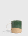 Pine 8 oz. Stoneware Mug (Angle): Dark green glazed upper half, unglazed speckled tan lower half, white handle