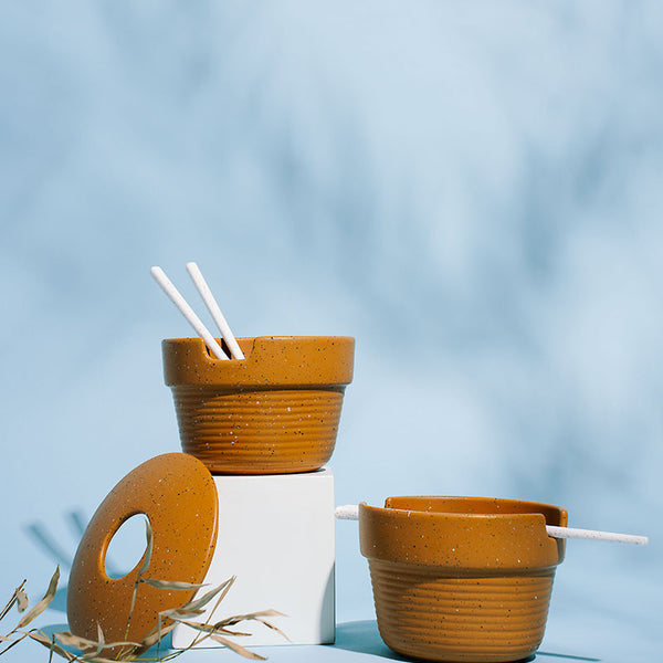 Caramel Stoneware Stackable Noodle Bowl Set (Angle): Two speckled amber bowls with ridged bases, white straws, donut lid