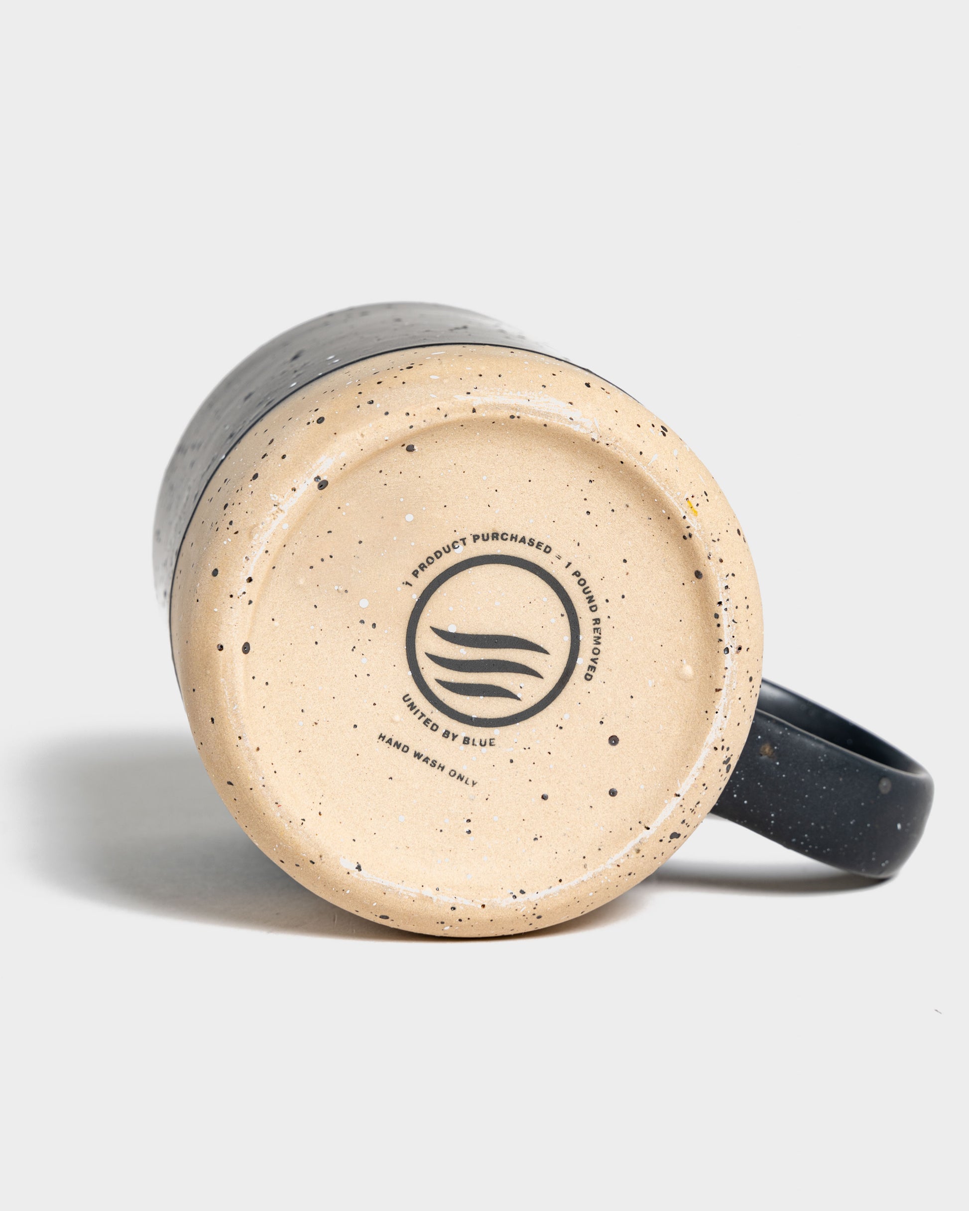 Black 8 oz. Stoneware Mug (Detail): Bottom of dark speckled stoneware mug showing brand logo and care text