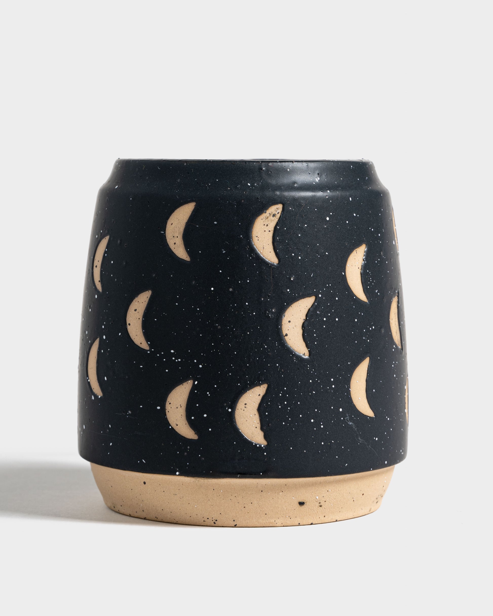 Nightfall Blue 16 oz. Stoneware Mug (Front): Dark navy speckled mug with carved crescent moon motifs and unglazed base