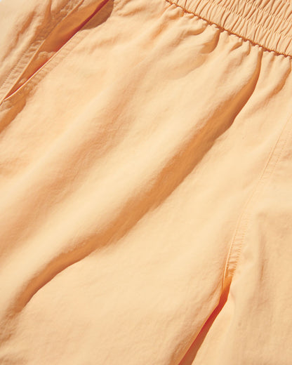 Buff Orange Recycled Sport Short (Detail): Close-up of smocked elastic waistband and lightweight peach-toned fabric