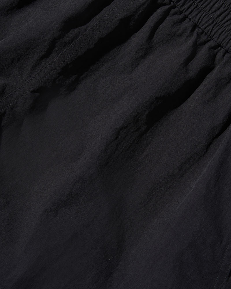 Black Recycled Sport Short (Detail): Close-up of black fabric with elastic waistband and subtle wrinkles