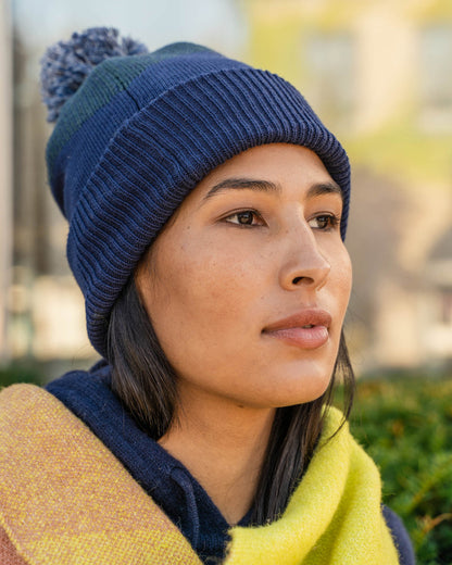 NAVY Recycled Chevron Pom Beanie (In-use): Woman wearing dark blue ribbed knit beanie with pom-pom outdoors