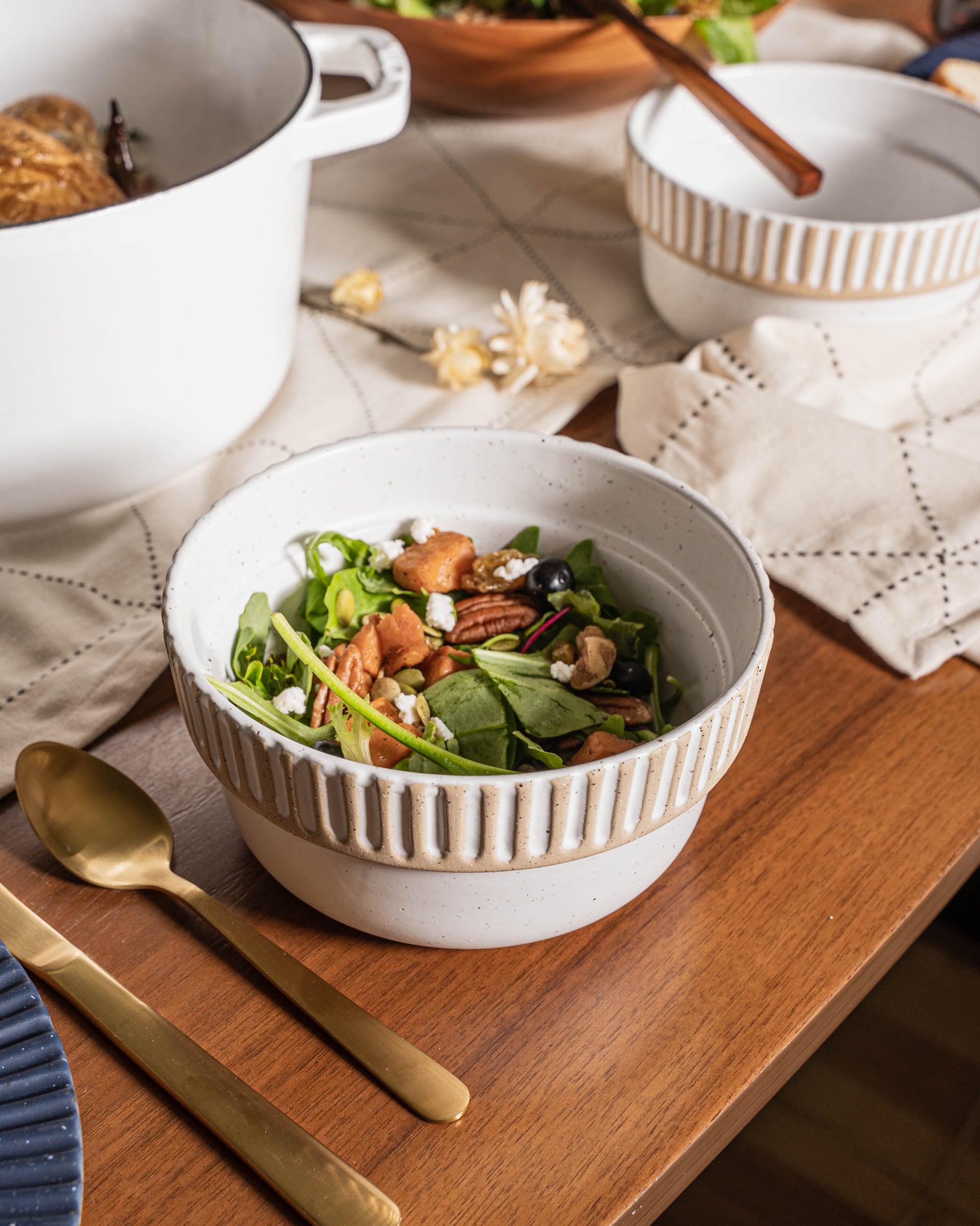Eggshell Stoneware Stackable Bowl (Lifestyle): Speckled white ribbed bowl filled with green salad, nuts, and blueberries