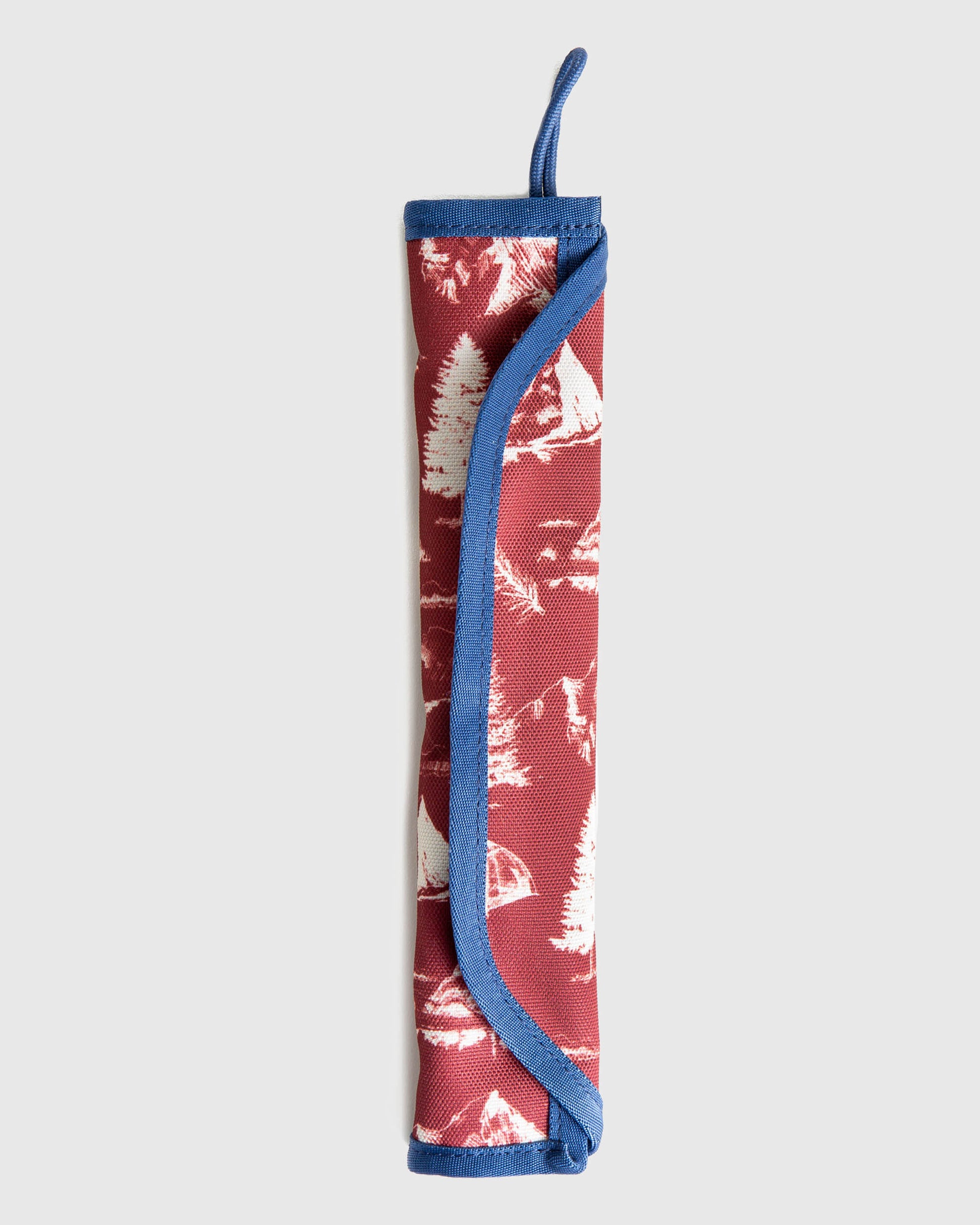 The Straw Kit (Flat-lay): Rolled red fabric kit with white nature print and blue trim loop