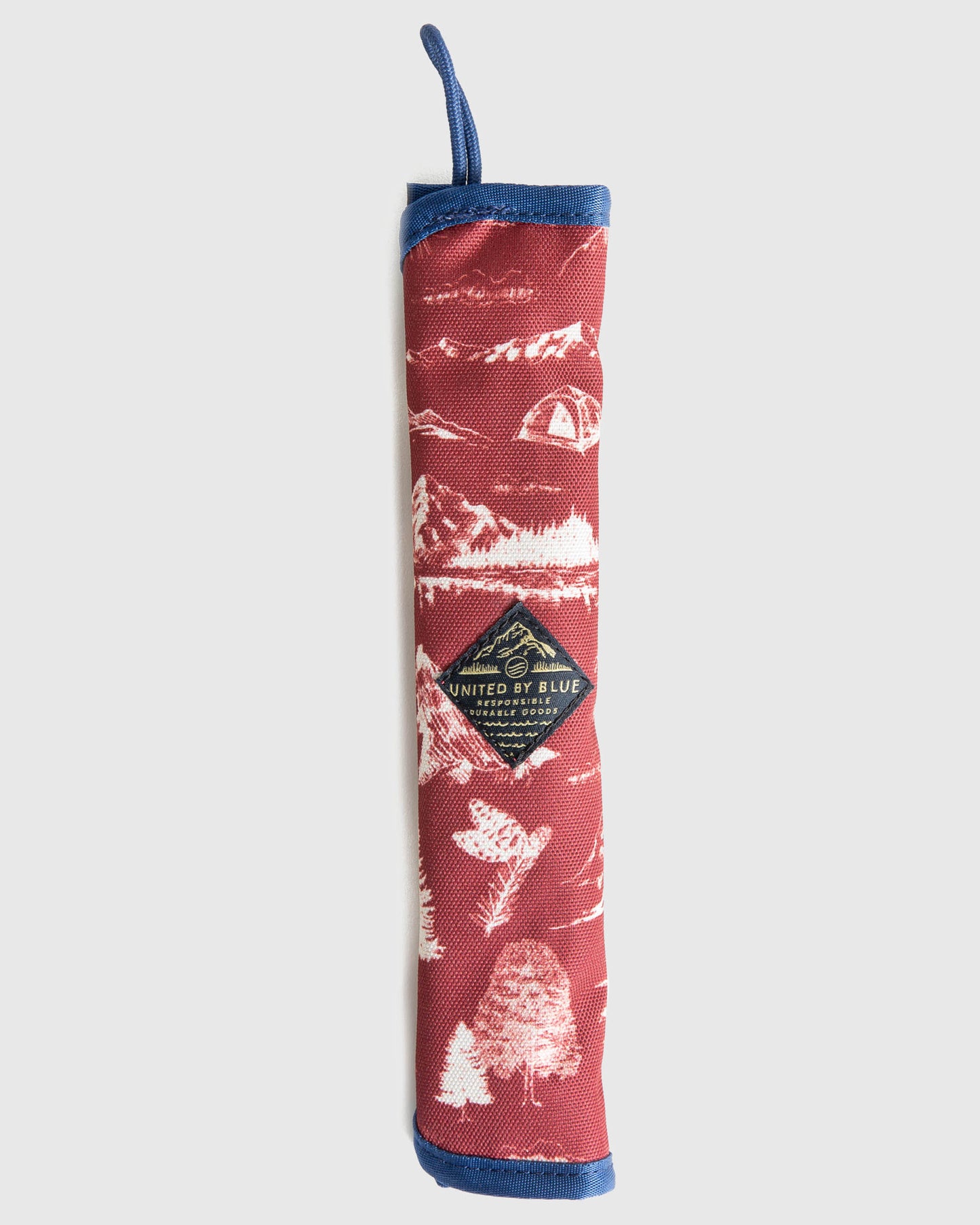 The Straw Kit (Front): Red canvas roll with white nature print, blue trim, and logo patch