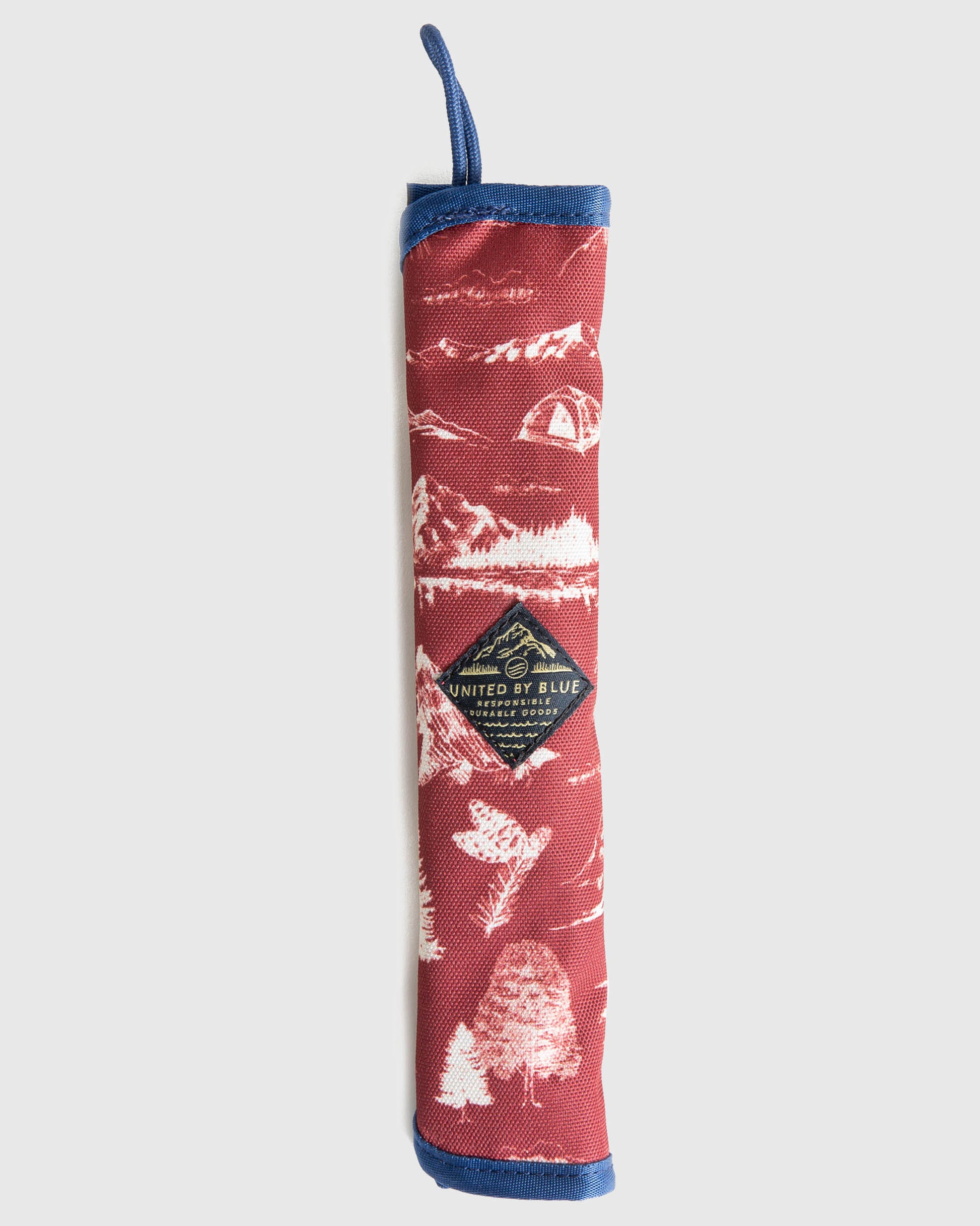 The Straw Kit (Front): Red canvas roll with white nature print, blue trim, and logo patch